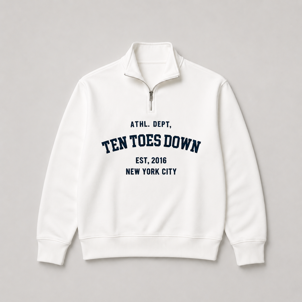 A white quarter-zip sweatshirt with navy blue collegiate-style oversized text reading 'TEN TOES DOWN'